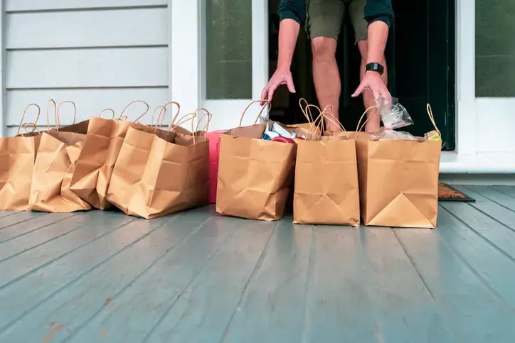 Customer collecting grocery bags left on their doorstep