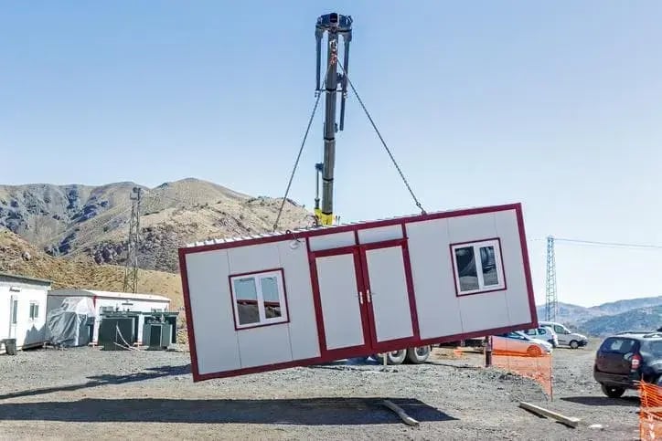 Crane lifting a portable site cabin into place